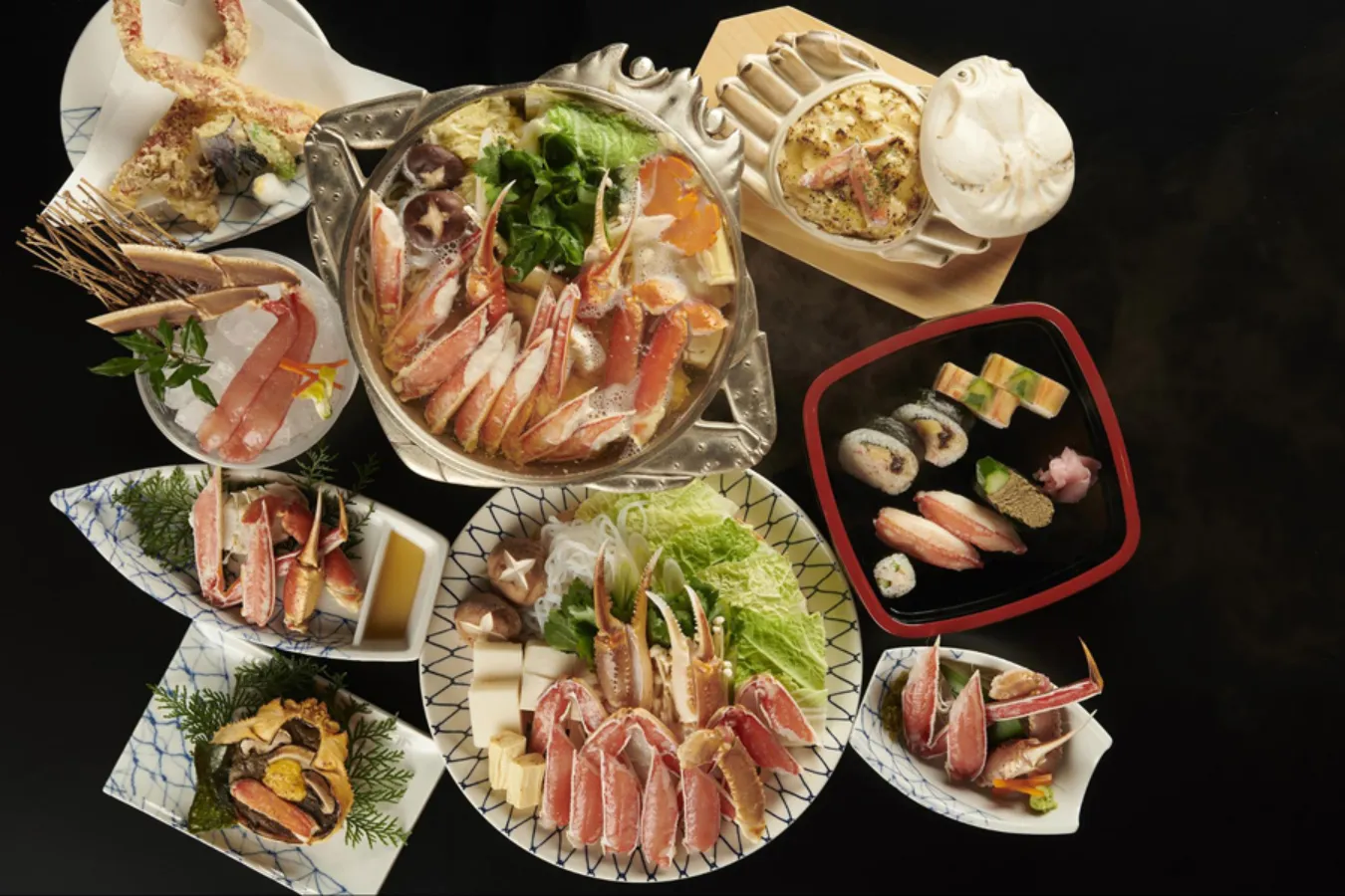 ▲中央「かにすき（鍋）」イメージ（2人前） 。左上「かに天ぷら」（3,600円）、「花氷（かに脚刺身）」（3,000円）、右上「かにグラタン」(1,800円）、「かに寿司盛り合わせ」(2,400円）など（すべて税抜）