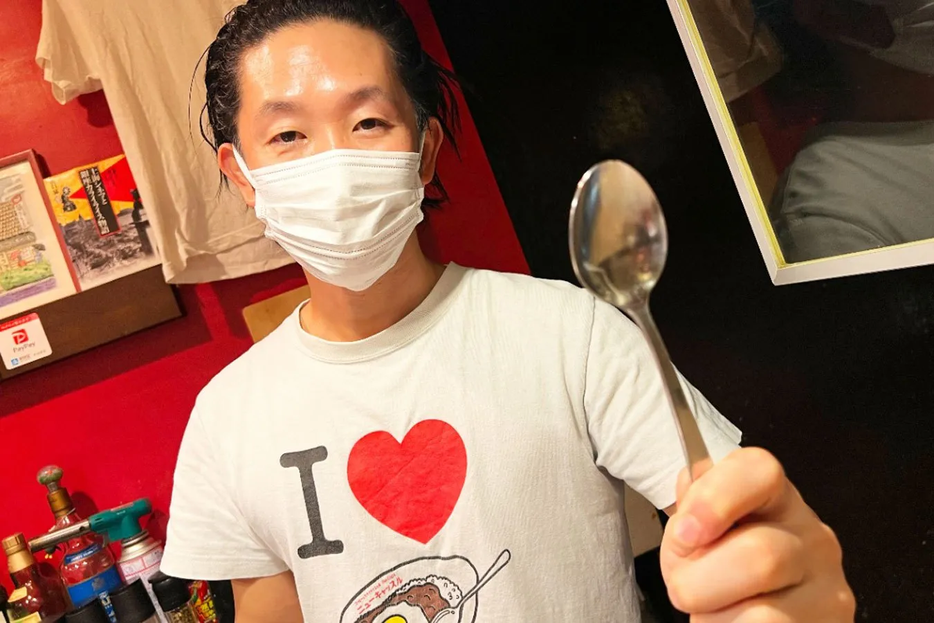 ▲たった一つ残った旧店舗のスプーンをもつ飯塚さん