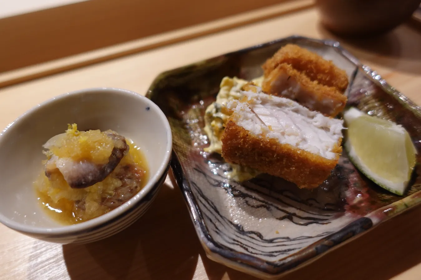 ▲太刀魚のフライ（右）となまこ酢（左）。おまかせコースの前半は、寿司店では珍しい逸品が続きます。