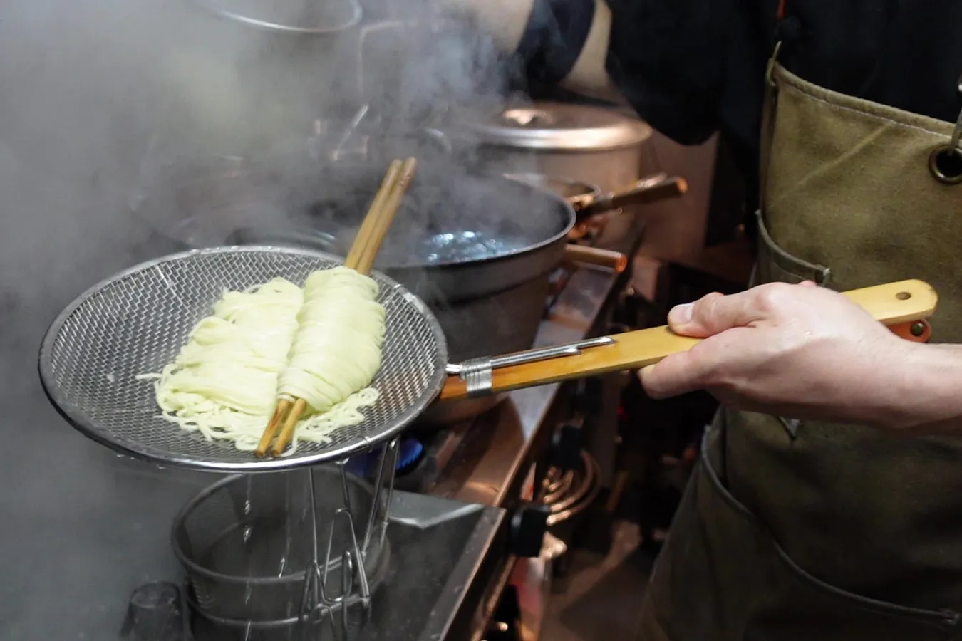 ▲茹でた麺を大きな鍋に移し、麺を泳がせながら平ざるで麺線を整えていく
