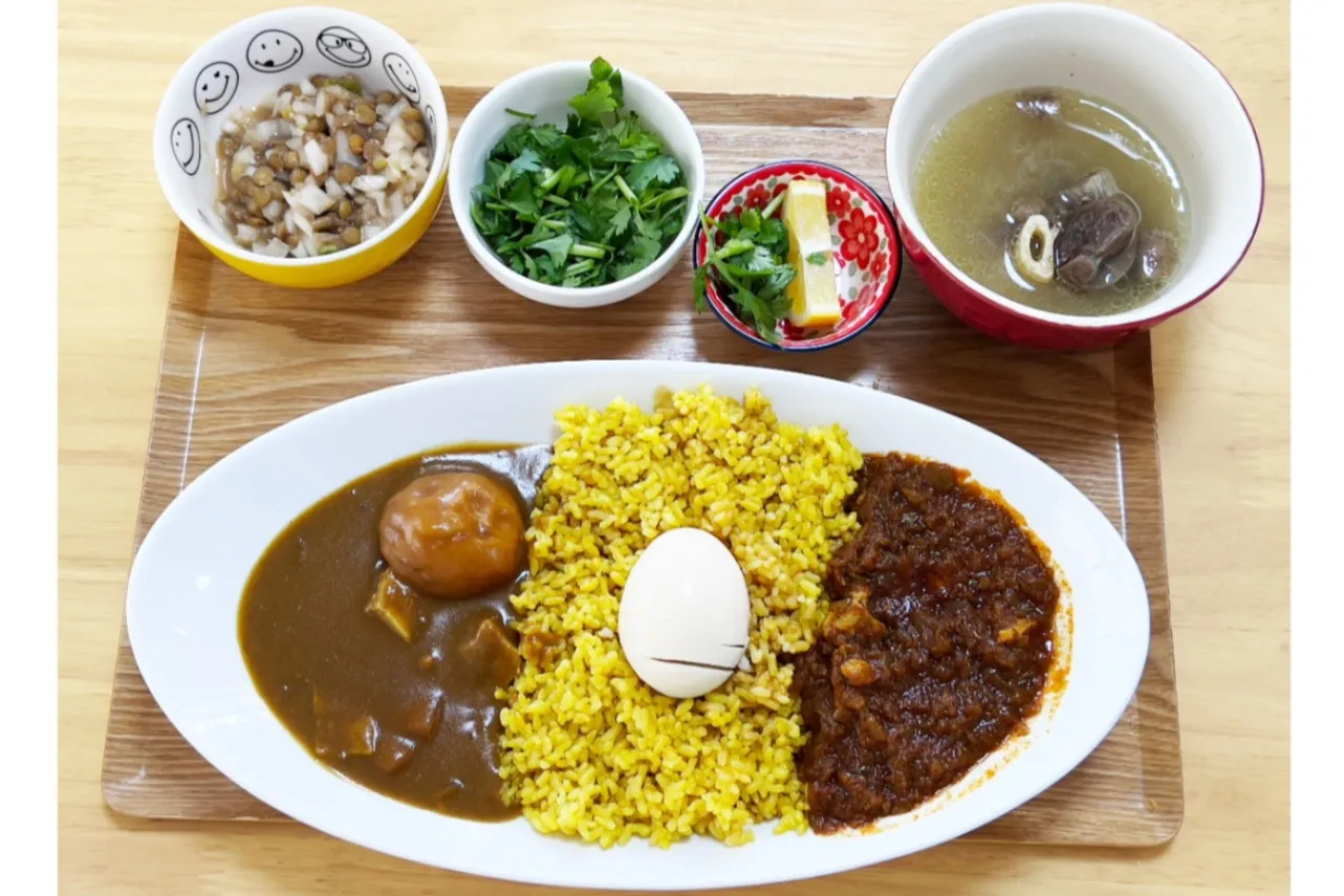 ▲「2種類のカレーとスペシャル定食」（1540円）。左はチキンカレー、右はドロワット。パクチーとクックルはサイドメニューとして追加したもの