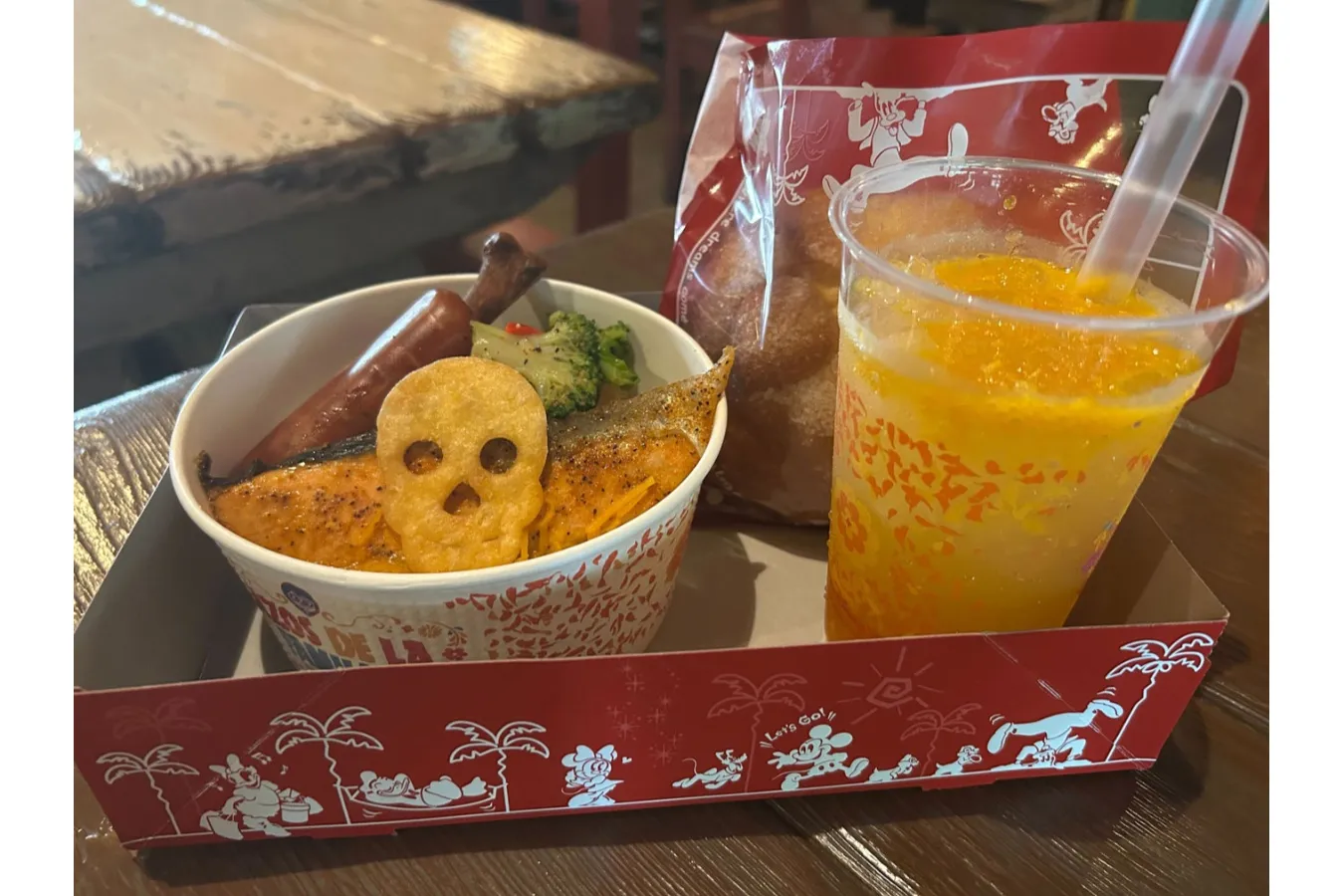 ▲左手前から「スペシャルセット」（1,780円）、「『リメンバー・ミー』ドリンク」（オレンジ＆マンダリンオレンジ、700円）、「スパイシースモークチキンレッグ」（1本600円）
