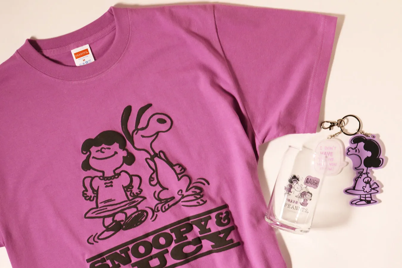 ▲「PEANUTS Cafe SMT カフェグラス」1,650円、「50's ビンテージTシャツ ルーシー」4,950円、「ラバーキーホルダー ルーシー」（1,980円）　(C) Peanuts Worldwide LLC