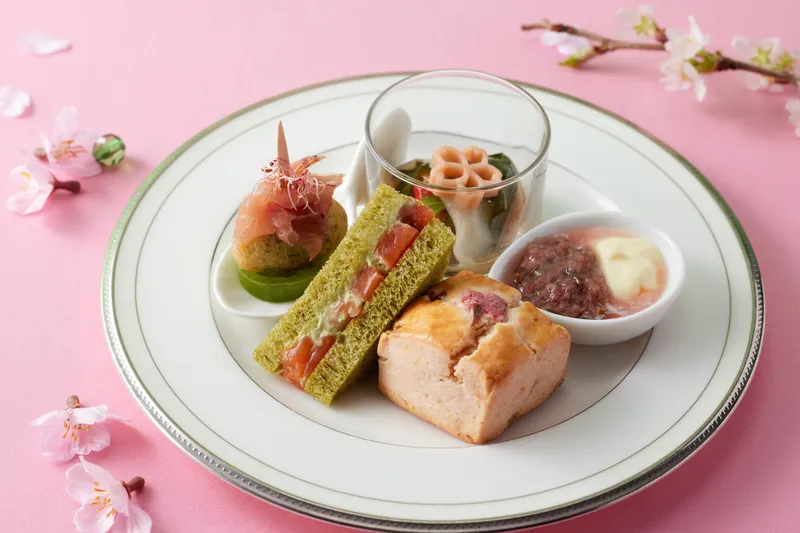 ・下段 桜の葉で包んだ白身魚のカルパッチョと緑黄野菜 桜パスタ 桜花ソース／ クロテッドクリーム＆桜ジャム／桜スコーン 桜チップで軽く燻製にしたサーモンとグリーンタルタルサンドイッチ／ 生ハムとゼッポリーネのピンチョス グリーントマトと桜エビ
