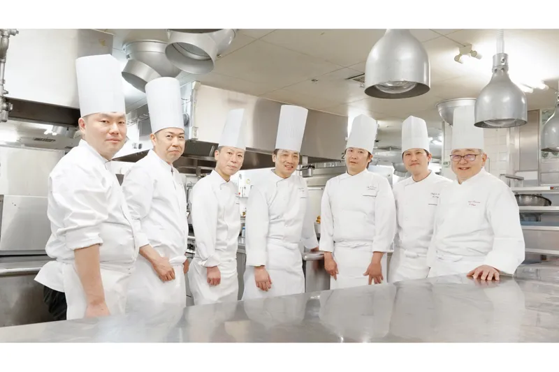左から：スーパーダイニング「リラッサ」和洋食統括シェフ 羽磨宏和 ／ スーパーダイニング「リラッサ」中華シェフ 山藤聡 ／ ダイニング「ドゥ ミル」シェフ 髙橋克友 ／ エグゼクティブシェフ 清水直徳 ／ スカイラウンジ＆ダイニング「アーティスト カフェ」シェフ 柏井辰方 ／ シェフ ド パティシエ 長島健二 ／ 中国料理「後楽園飯店」料理長 稲飯龍典